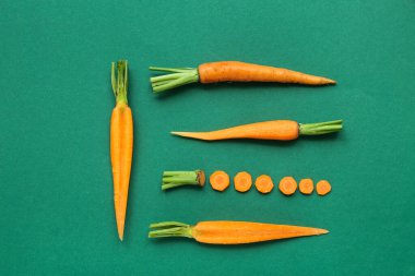 Dilimlenmiş, soyulmuş ve yeşil zemin üzerinde taze havuçlar.