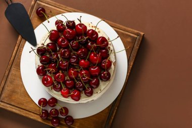 Ahşap tahta, kırmızı arka planda vişneli pasta.