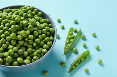 Mavi arka planda taze bezelye kabı