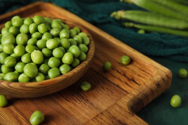 Taze bezelyeli kase ve ahşap tahta, yakın plan.