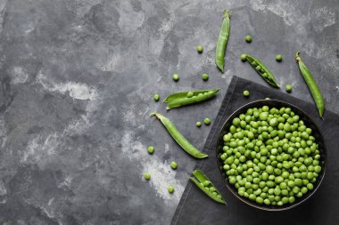 Gri arkaplanda taze bezelye kabı