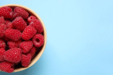 Mavi arka planda taze ahududu tabağı