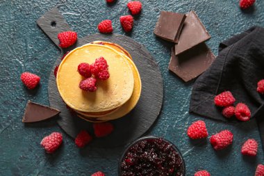 Siyah arkaplanda ahududu olan lezzetli krepler.