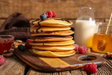 Ahşap arka planda ahududu ve yaban mersinli lezzetli krepler.