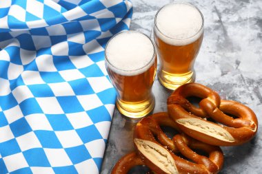 Bavyera bayrağı, biralı kupalar ve mavi arka planda krakerler.