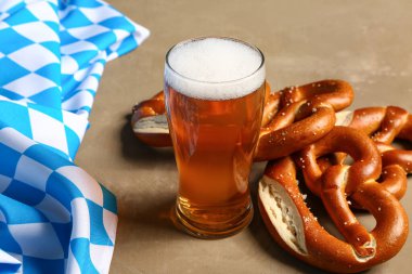 Bavyera bayrağı, biralı bardak ve kahverengi arka planda kraker.