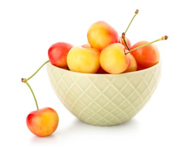 Beyaz arka planda sarı kirazlı bir kase.