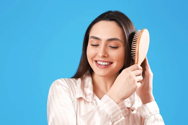 Pretty Young Woman Brushing Hair Blue Background — Stock Photo, Image