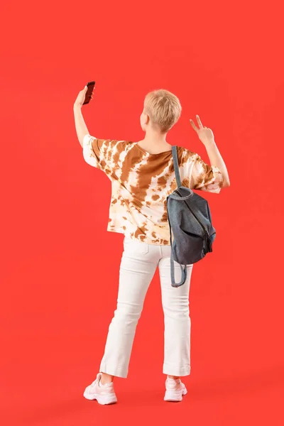 Studentin Mit Rucksack Macht Selfie Auf Rotem Hintergrund Rückansicht — Stockfoto