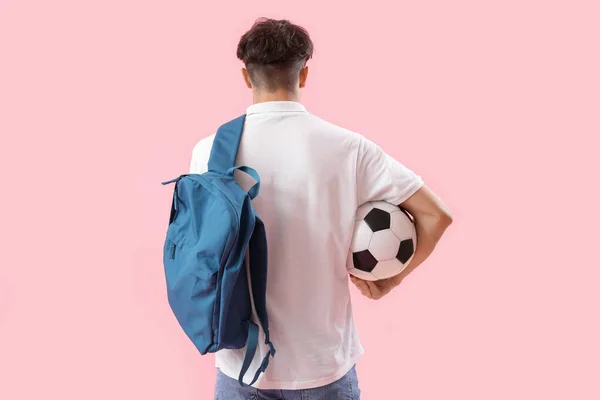 バックパックとサッカーボールを持つ男性学生ピンクの背景 バックビュー — ストック写真