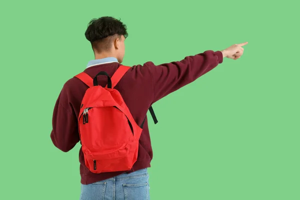 Man Student Med Ryggsäck Pekar Något Grön Bakgrund Baksida — Stockfoto