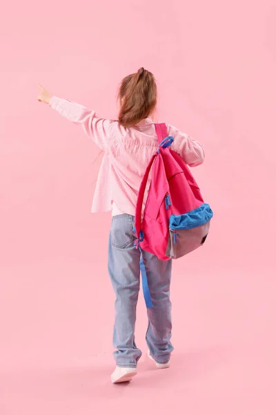 Malá Školačka Batohem Ukazuje Něco Růžovém Pozadí Pohled Zezadu — Stock fotografie