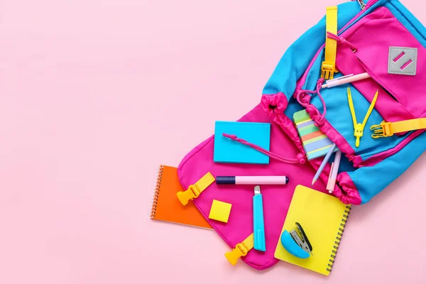 ピンクの背景にノートや文房具付きカラースクールバックパック — ストック写真