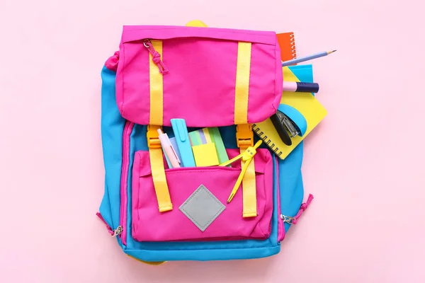 带粉红背景笔记本和文具的彩色学校背包 — 图库照片