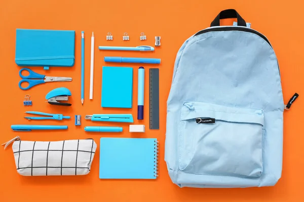 Blauer Schulrucksack Mit Mäppchen Und Schreibwaren Auf Orangefarbenem Hintergrund — Stockfoto