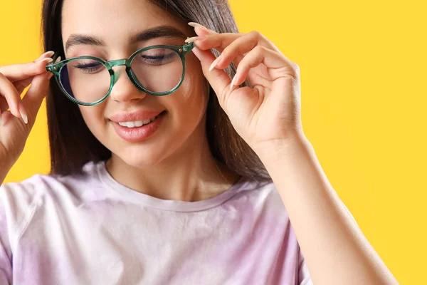 Sarı Arka Planda Gözlük Takan Güzel Bir Genç Kadın — Stok fotoğraf