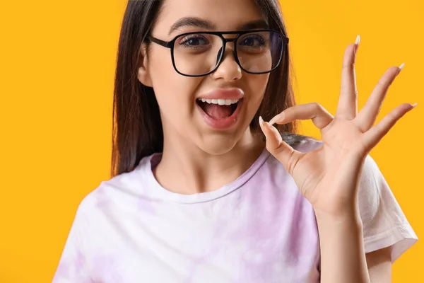 Ładna Młoda Kobieta Nosi Okulary Pokazuje Żółtym Tle — Zdjęcie stockowe