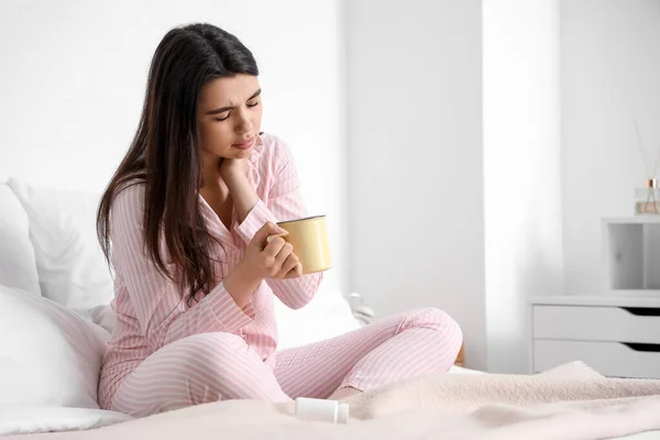 病気の若い女性飲む熱いお茶でベッド — ストック写真