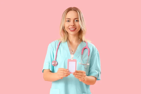 Vrouwelijke Medische Stagiaire Met Badge Roze Achtergrond — Stockfoto