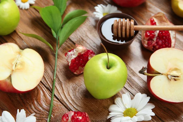Tahta arka planda taze meyve, çiçek ve bal içeren kompozisyon, yakın plan. Rosh hashanah (Yahudi Yeni Yılı) kutlaması