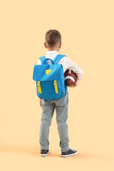 蓝色背包和橙色背景橄榄球的小学生 后视镜 — 图库照片
