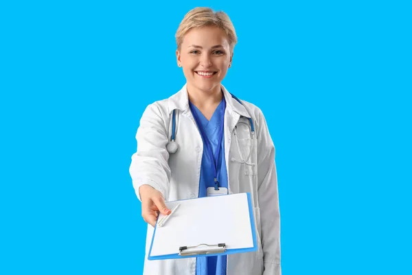 Female Medical Intern Clipboard Blue Background — стоковое фото