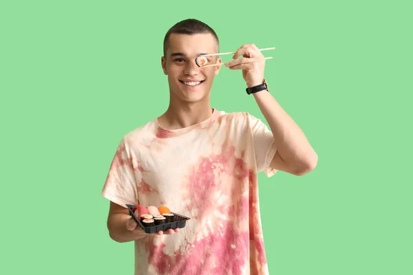 Young Man Tasty Sushi Green Background — Stock Photo, Image