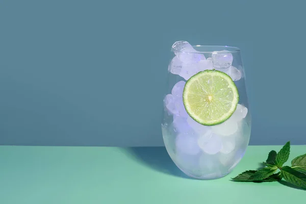 Glas Ijsblokjes Limoenschijfje Met Munt Turquoise Tafel Bij Muur — Stockfoto