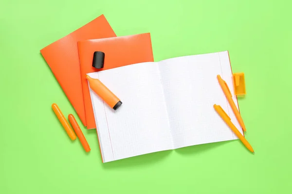緑の背景にマーカーとオレンジノートブック — ストック写真