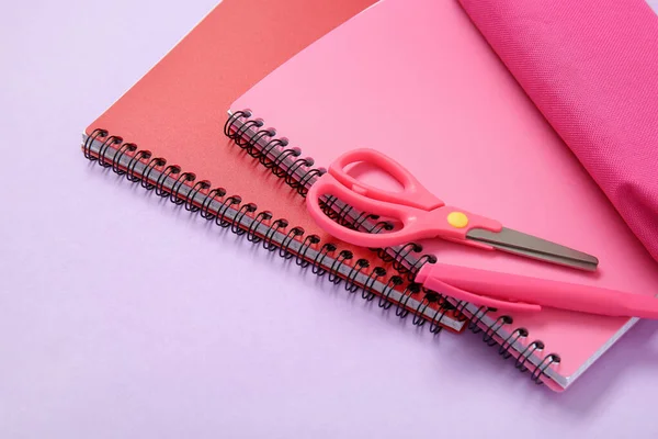 夹杂着铅笔盒和不同文具的紫丁香背景笔记本 — 图库照片