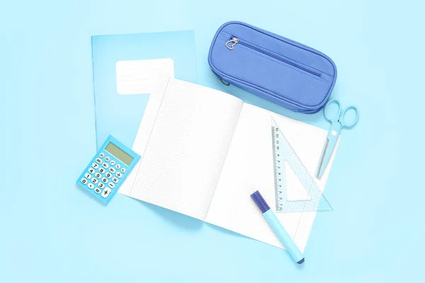 带有铅笔盒和蓝色背景的不同文具的笔记本 — 图库照片