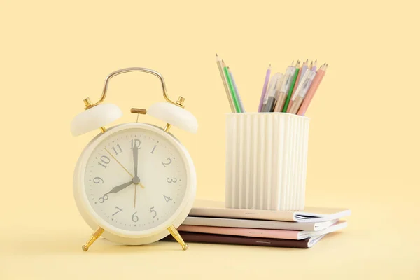 Reloj Despertador Con Cuadernos Soporte Papelería Sobre Fondo Amarillo —  Fotos de Stock