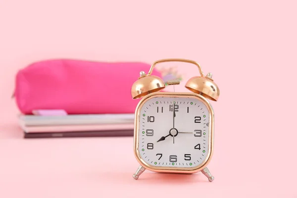 ピンクの背景にノートと鉛筆ケース付き目覚まし時計 — ストック写真