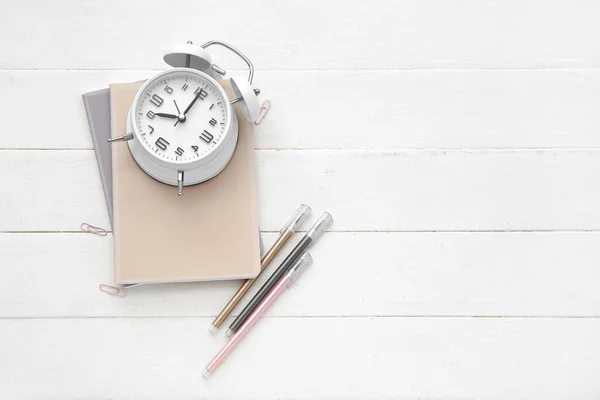 Alarm Clock Notebooks Pens White Wooden Background — Stock Photo, Image