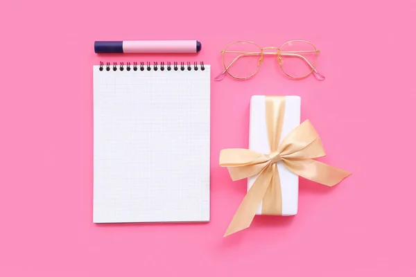 打开装有礼品盒 眼镜和粉红背景标识的笔记本 — 图库照片
