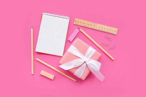 带礼品盒和粉红背景的不同文具的开机笔记本 — 图库照片