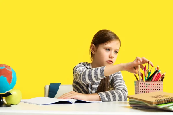 Kleines Mädchen Gibt Unterricht Tisch Auf Gelbem Hintergrund — Stockfoto