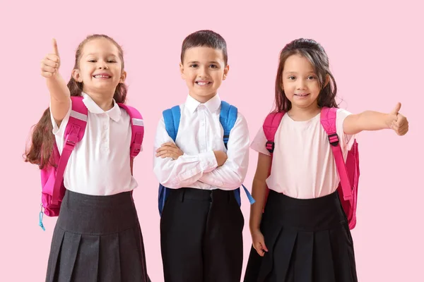 Pembe Arka Planda Baş Parmak Gösteren Küçük Okul Çocukları — Stok fotoğraf