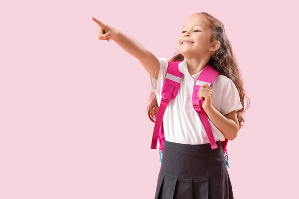 Μικρή Μαθήτρια Σακίδιο Που Δείχνει Κάτι Ροζ Φόντο — Φωτογραφία Αρχείου