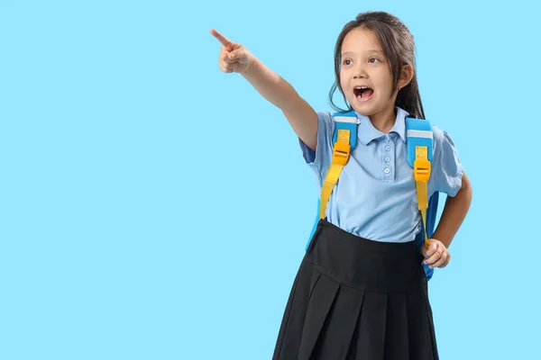 Маленька Школярка Рюкзаком Вказує Щось Світло Блакитному Тлі — стокове фото