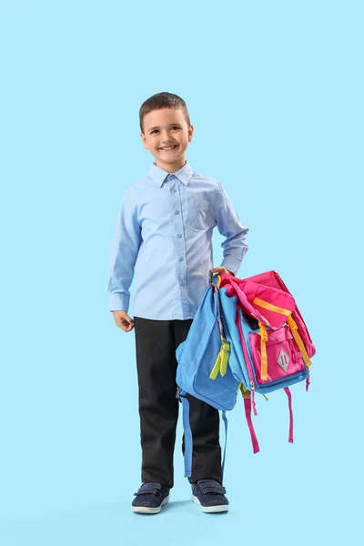 Açık Mavi Arka Planda Sırt Çantaları Olan Küçük Okul Çocuğu — Stok fotoğraf