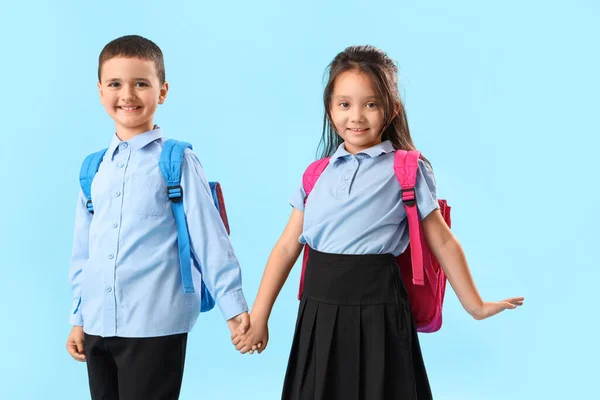 Kleine Schulkinder Halten Händchen Auf Hellblauem Hintergrund — Stockfoto