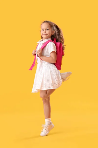 Springen Klein Schoolmeisje Gele Achtergrond — Stockfoto