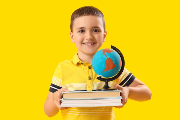 Kleiner Schuljunge Mit Büchern Und Globus Auf Gelbem Hintergrund — Stockfoto
