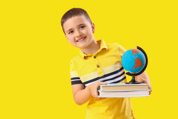 Kleiner Schuljunge Mit Büchern Und Globus Auf Gelbem Hintergrund — Stockfoto