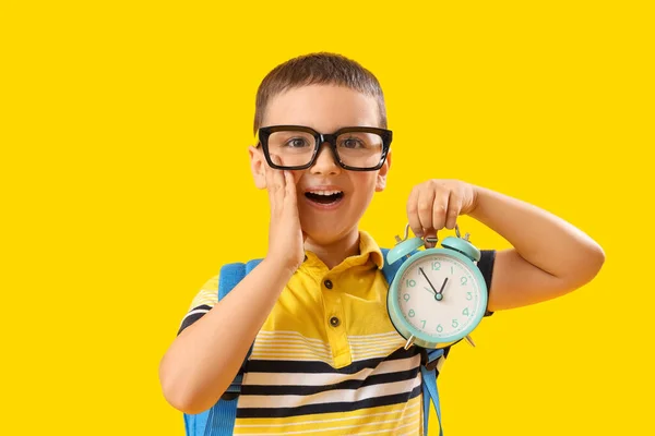 幸せな小さな男の子とともに目覚まし時計上の黄色の背景 — ストック写真