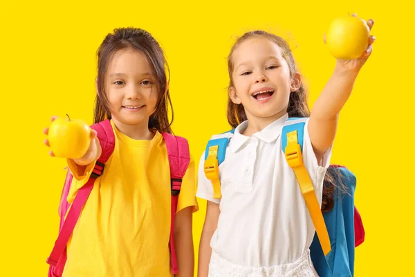 Kleine Schülerinnen Mit Äpfeln Auf Gelbem Hintergrund — Stockfoto