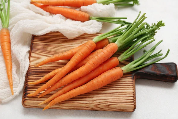 Holzbrett Mit Frischen Karotten Auf Weißem Strukturiertem Hintergrund — Stockfoto