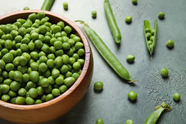 stock image Bowl with fresh green peas on grunge background