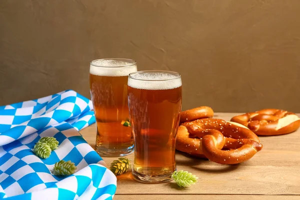 Flag of Bavaria, mugs with beer and pretzels on wooden table
